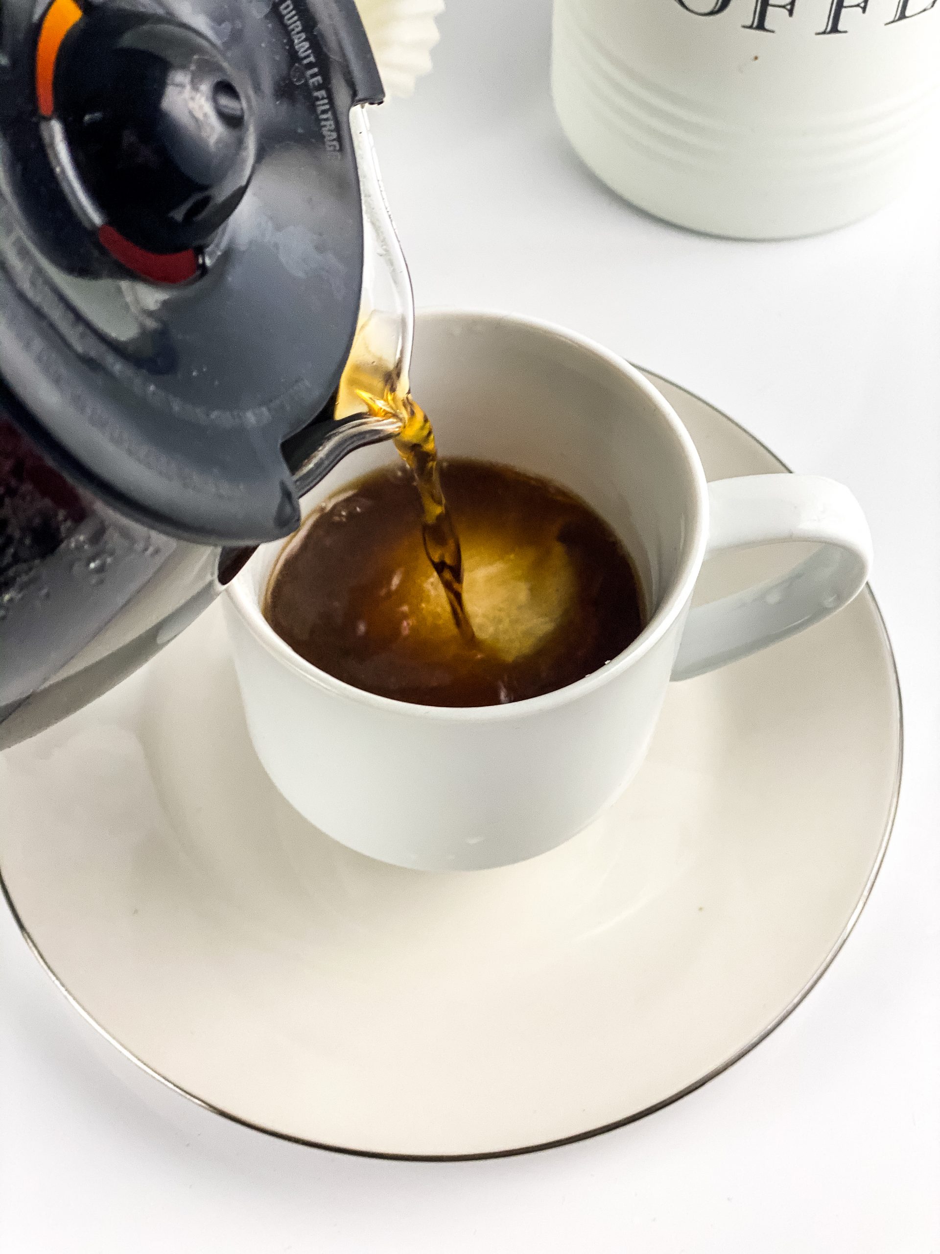 pouring a pot of coffee into a mug containing a creamer bomb