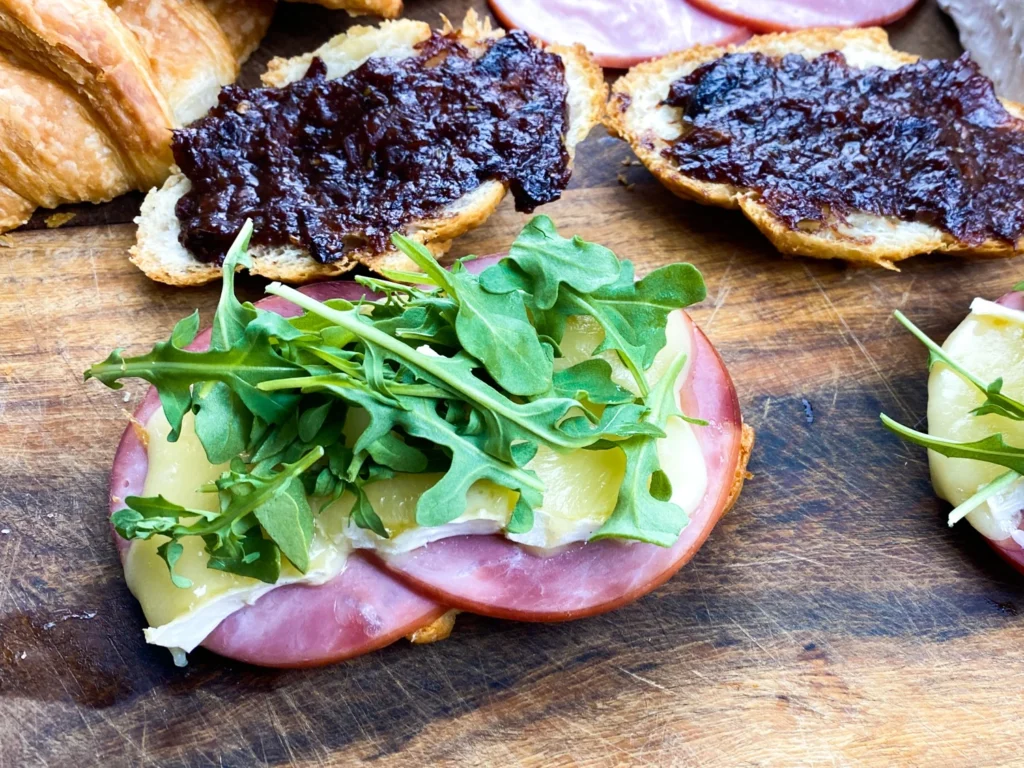 Fresh arugula added to melted Brie and ham before topping with buttery croissants.