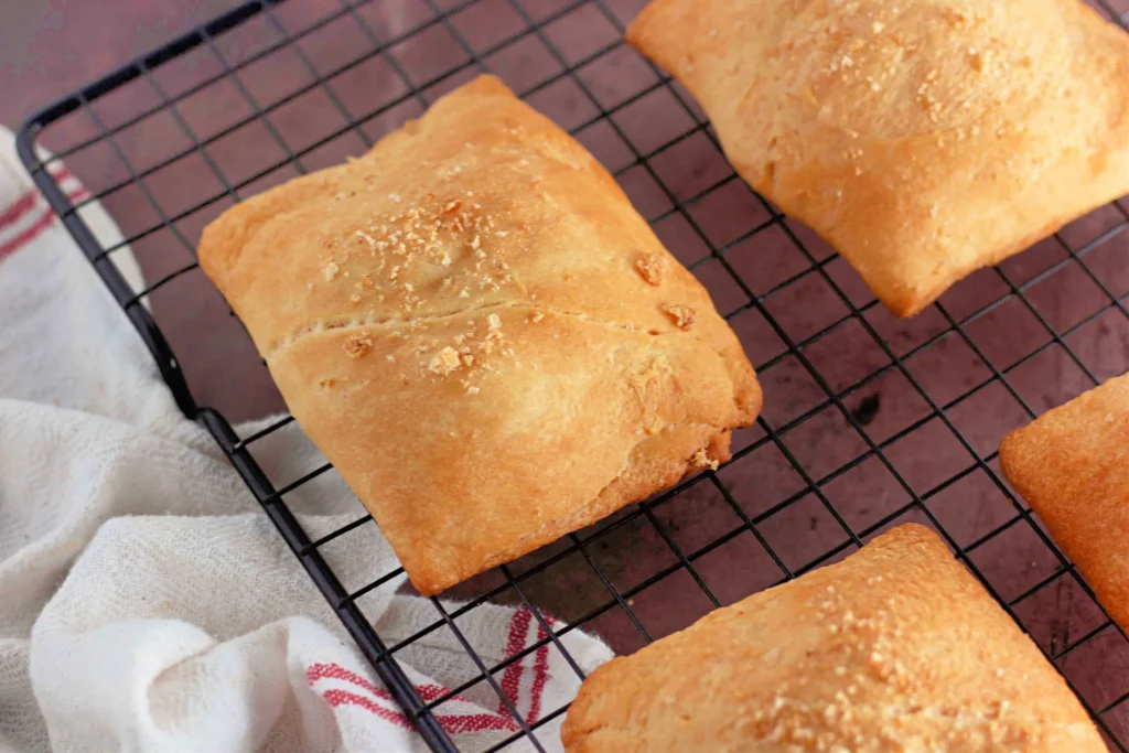 Freshly baked chicken crescent pockets cooling on a wire rack.