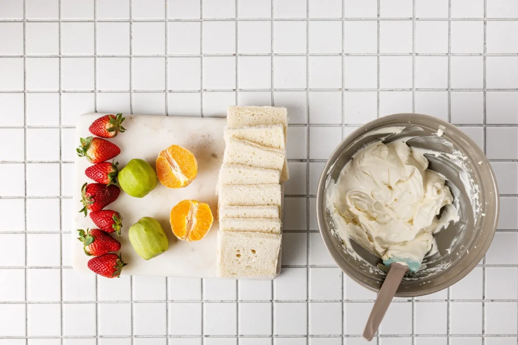 Prepared whipped cream and sliced fruit ready for Japanese fruit sando assembly.