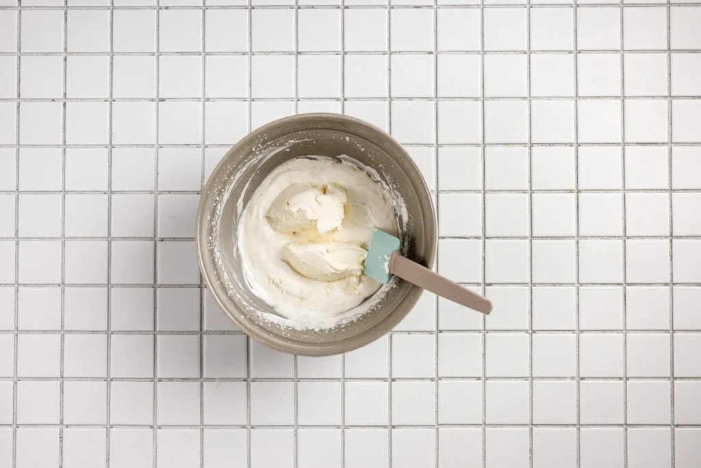 Heavy cream whipped to soft peaks in a mixing bowl for Japanese fruit sandwiches.