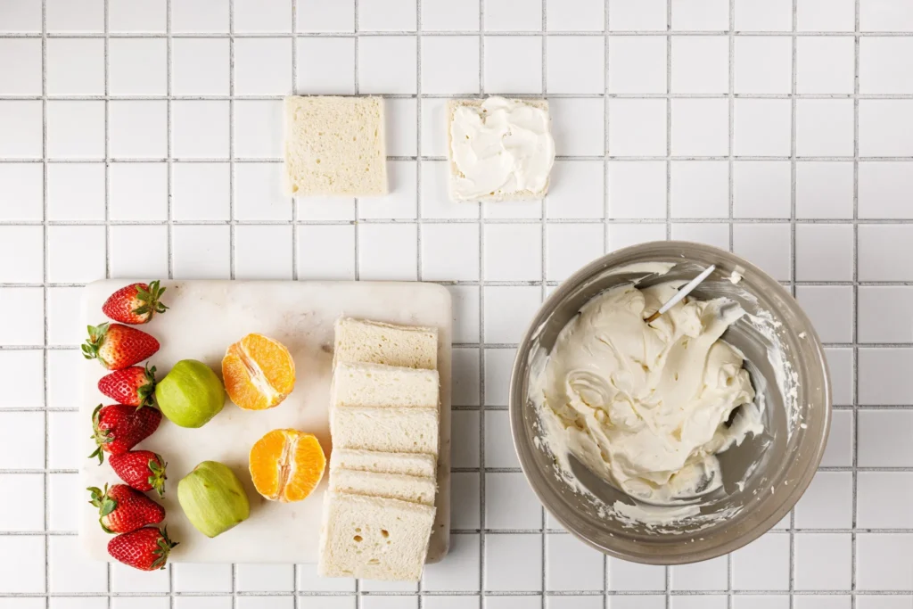Bread slice being spread with whipped cream to start assembling a fruit sando.