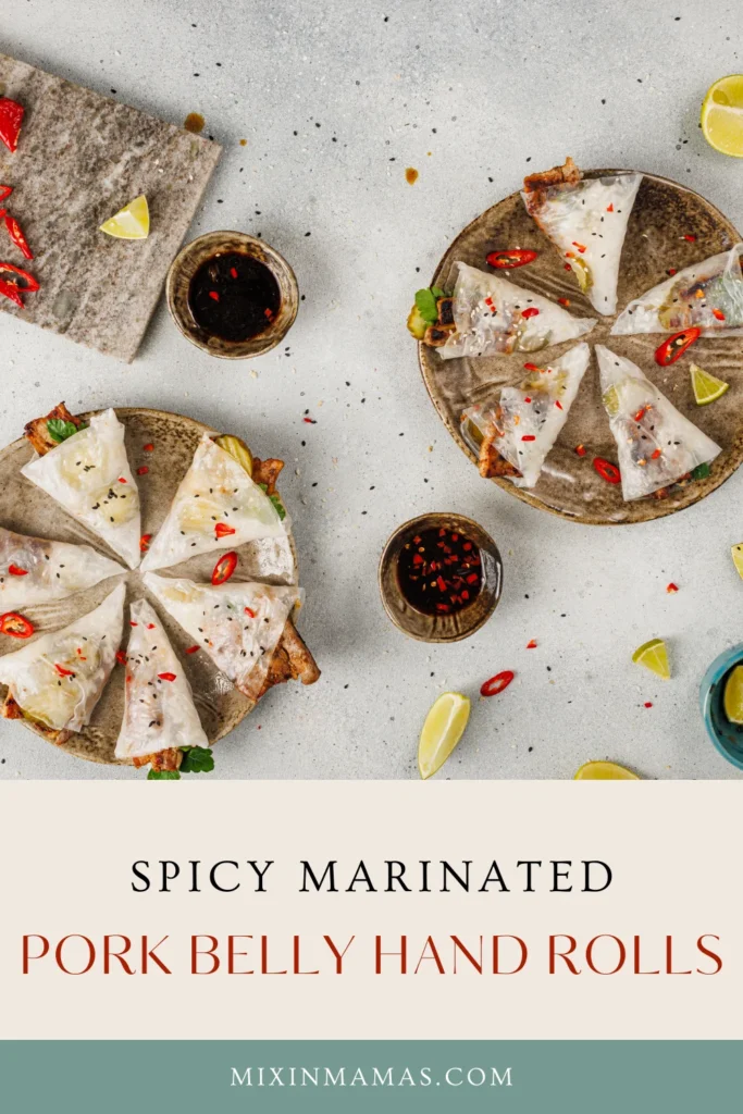 Overhead flatlay of Asian pork belly hand rolls with sesame seeds, chili slices, and lime wedges.