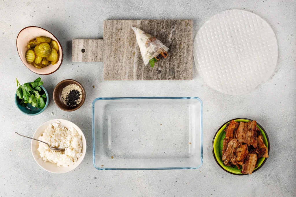 Spicy pork belly hand roll being wrapped tightly in rice paper, ready to serve.