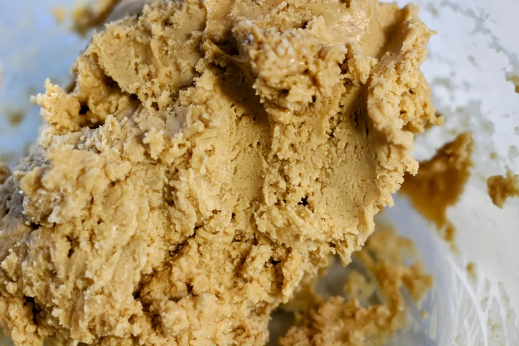 Thick peanut butter filling dough forming in the mixing bowl.