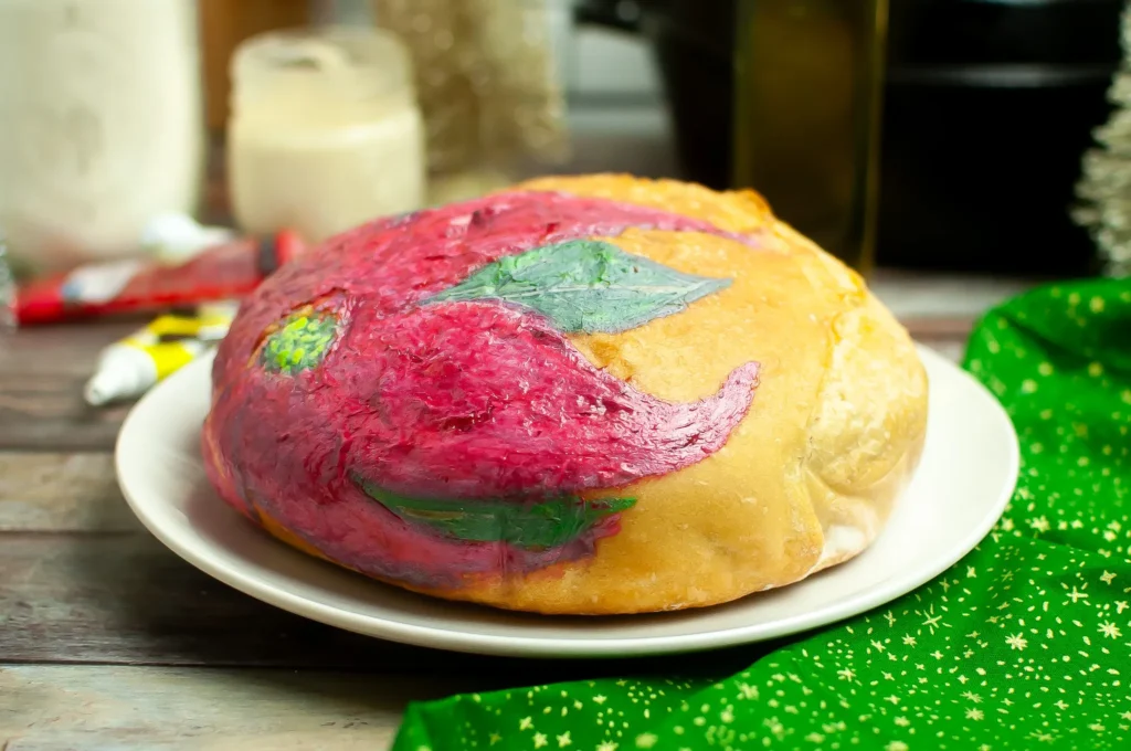 Side view of the baked loaf highlighting the texture of the painted poinsettia petals and leaves.