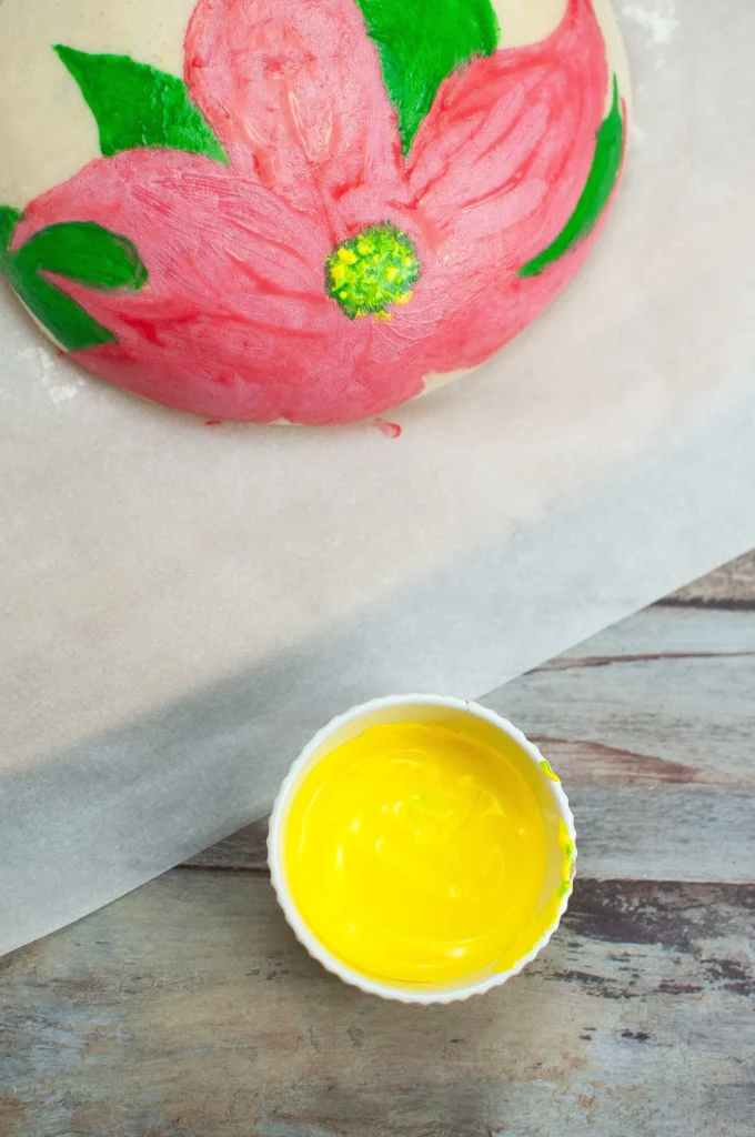 Yellow coloring being added to the center of the poinsettia design to finish the flower.