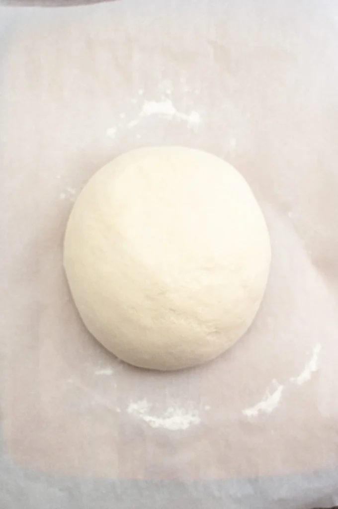 Shaped loaf resting on parchment paper, ready to be painted.