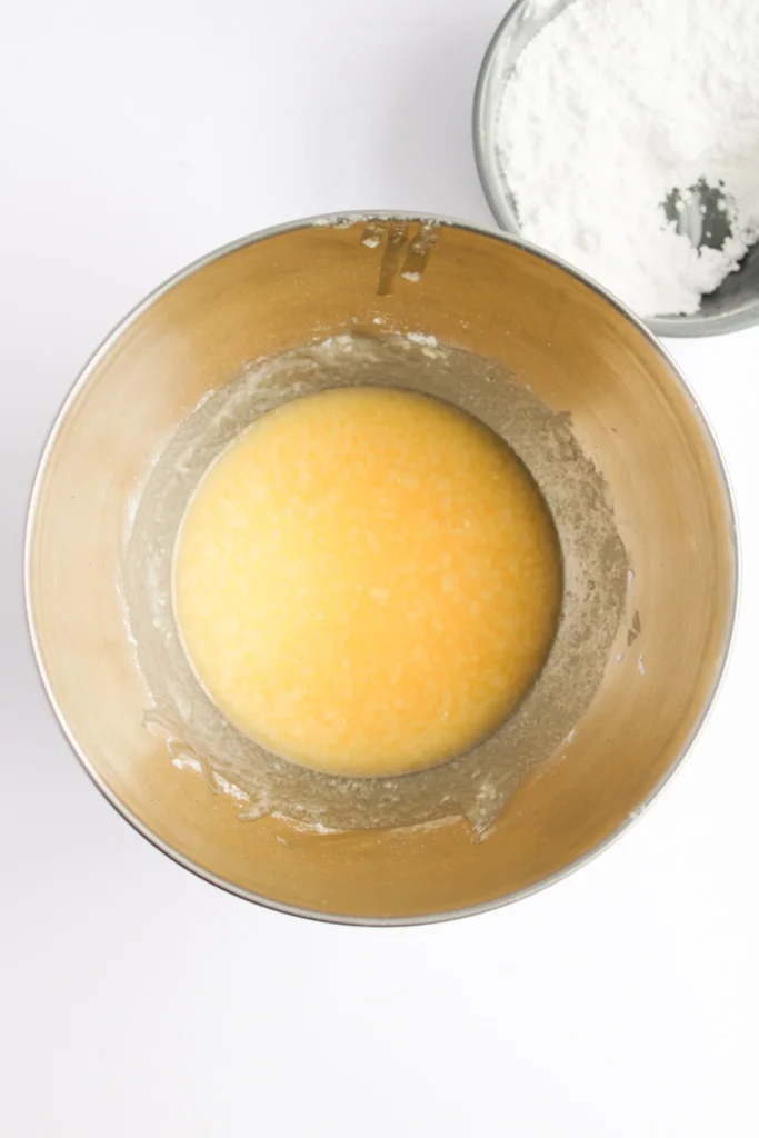 Butter and powdered sugar mixture in a mixing bowl for cupcake frosting