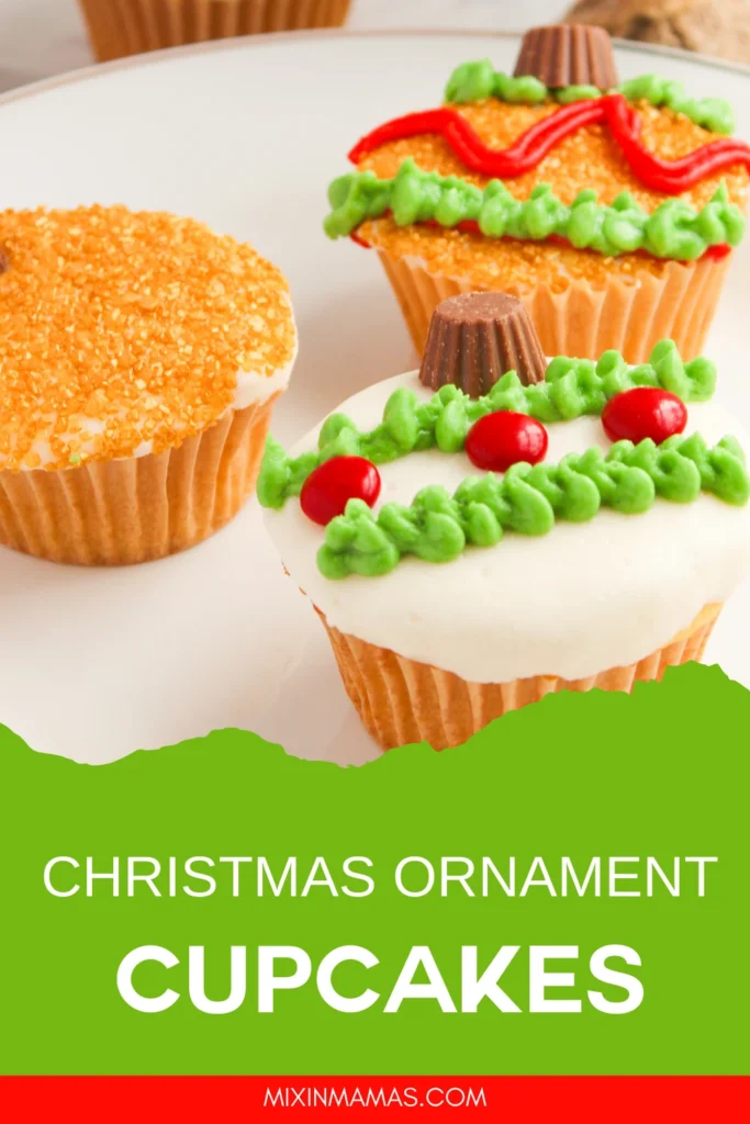 Christmas ornament cupcakes with green frosting garlands, red candy accents, and sanding sugar styled for a festive holiday dessert