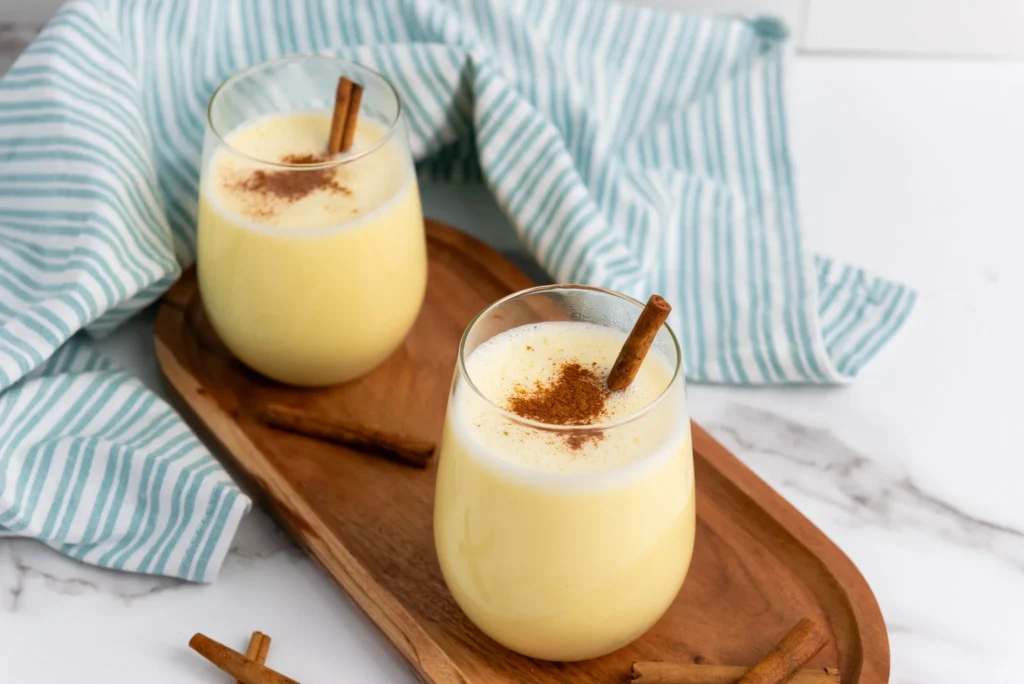 Creamy homemade eggnog served in glasses with cinnamon garnish