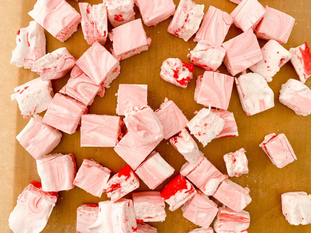 Cut homemade peppermint marshmallows on parchment paper