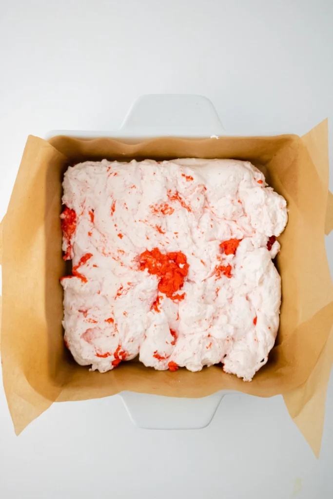 Peppermint extract being added to whipped marshmallow mixture