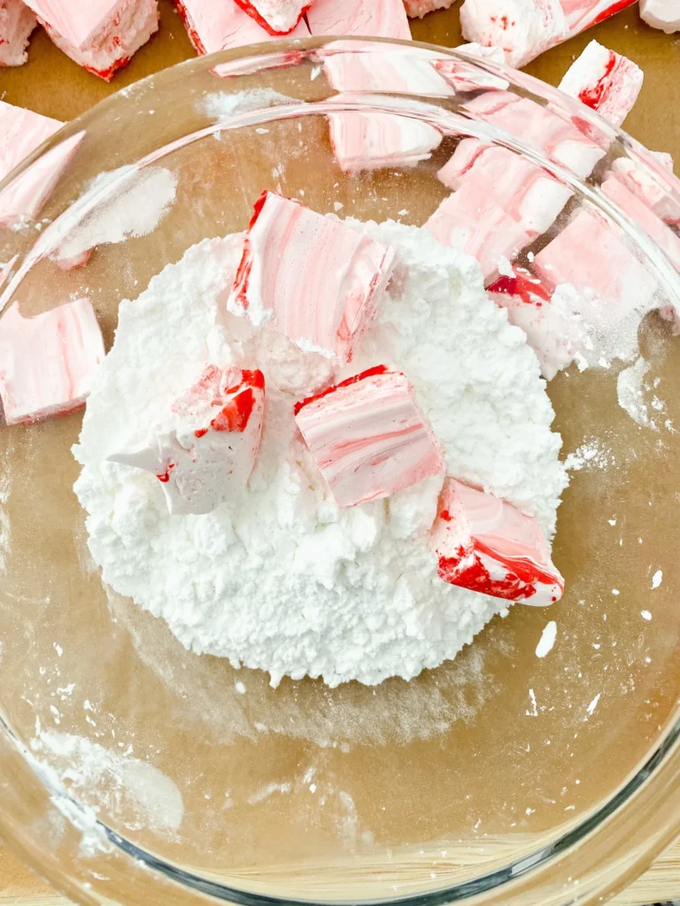 Peppermint marshmallows coated in powdered sugar in glass bowl