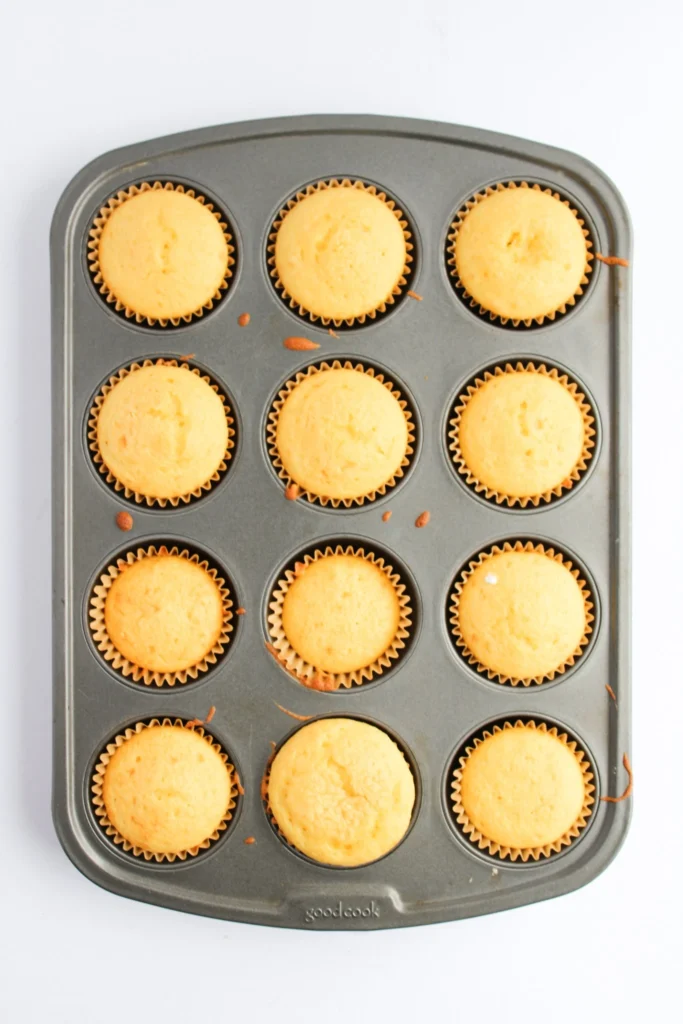 Plain vanilla cupcakes baked in a muffin tin and ready to be decorated
