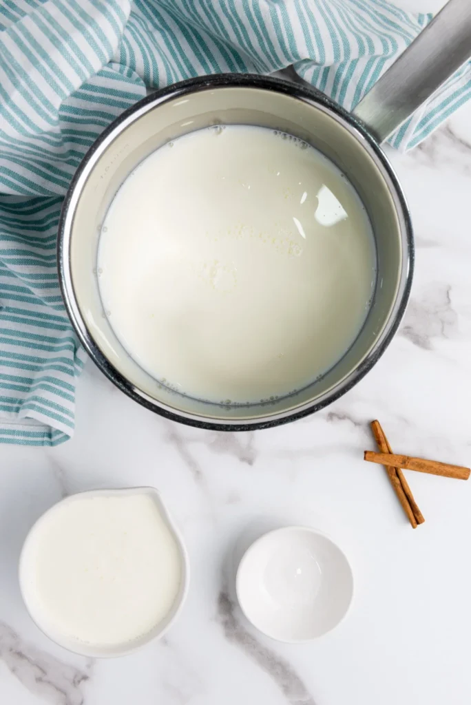 Milk and cream warming in a saucepan for homemade eggnog