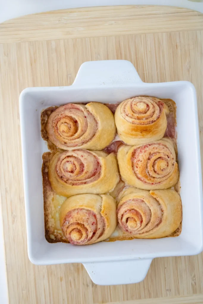 Freshly baked strawberry sweet rolls in a white baking dish
