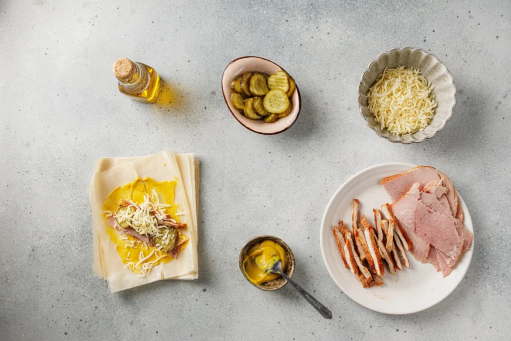 Cuban sandwich egg roll filling with pork ham pickles cheese and mustard on wrapper