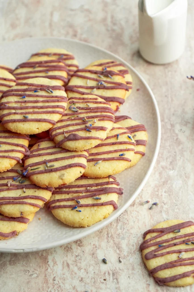 Close-up of lavender cookies topped with purple icing and dried lavender buds.