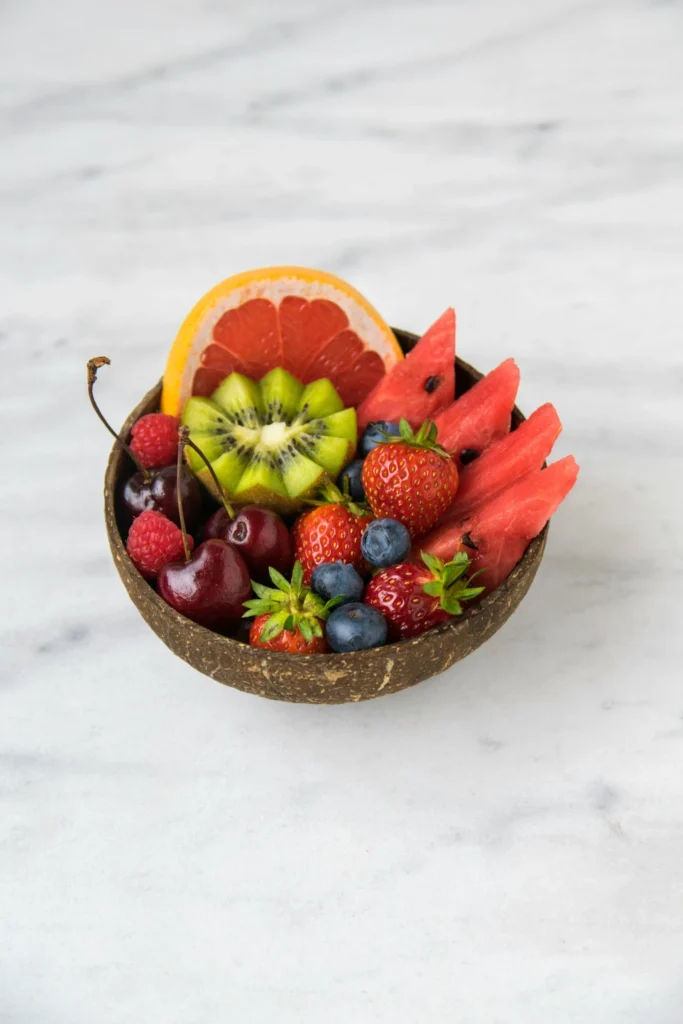 Small bowl filled with fresh fruit including watermelon, kiwi, cherries, strawberries, blueberries, and raspberries.