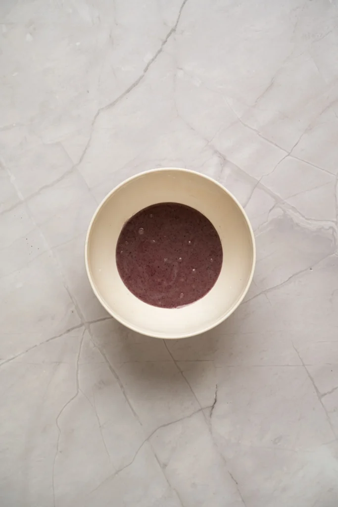 Lavender cookie icing mixed into a soft purple color in a bowl.