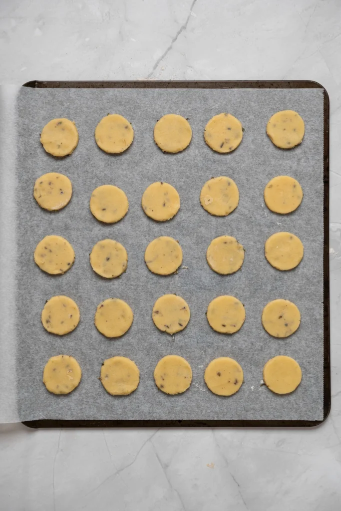 Unbaked lavender cookies arranged on a parchment-lined baking sheet.
