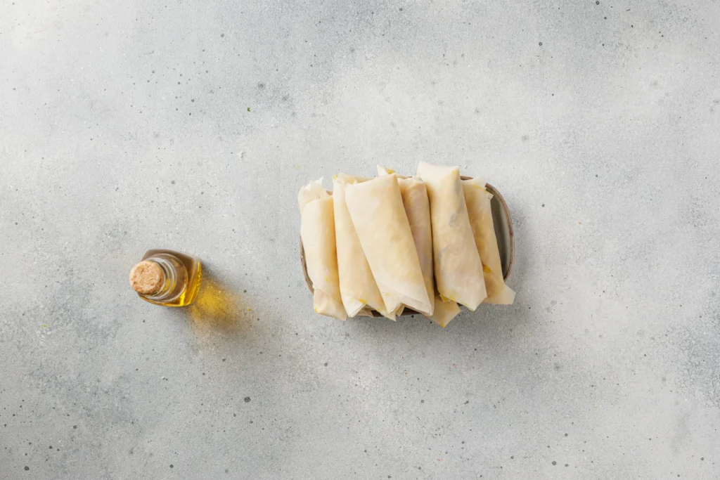 Uncooked Cuban sandwich egg rolls prepared for frying