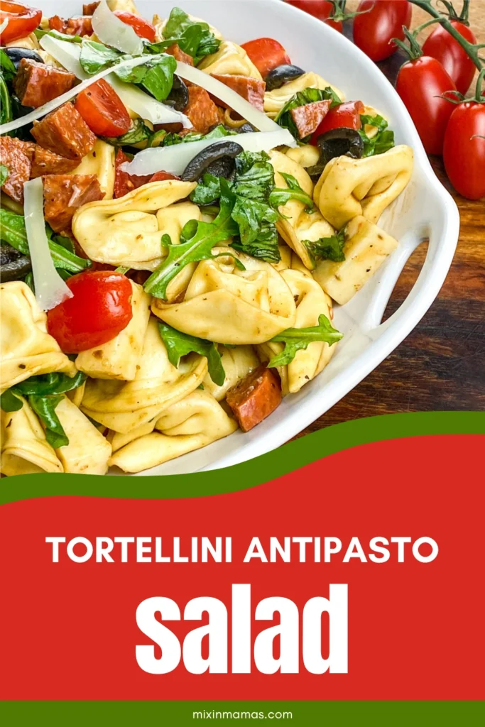 Pinterest graphic for Tortellini Antipasto Salad featuring a close-up of the finished salad with tomatoes, olives, arugula, pepperoni, and shaved Parmesan.