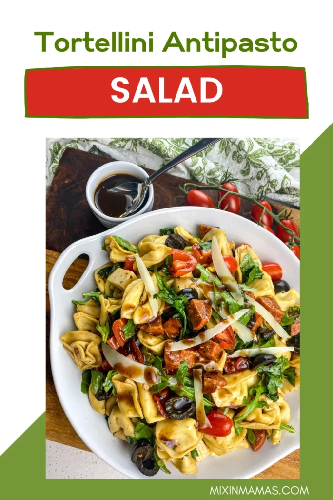 Vertical Pinterest pin showing a serving platter of Tortellini Antipasto Salad with balsamic vinaigrette and fresh tomatoes.