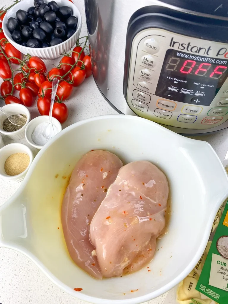 Marinated chicken breasts prepared for cooking in an Instant Pot for tortellini chicken skewers.