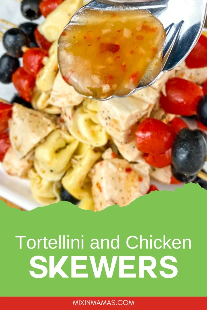 Spoonful of Italian dressing above tortellini and chicken skewers with tomatoes and black olives.