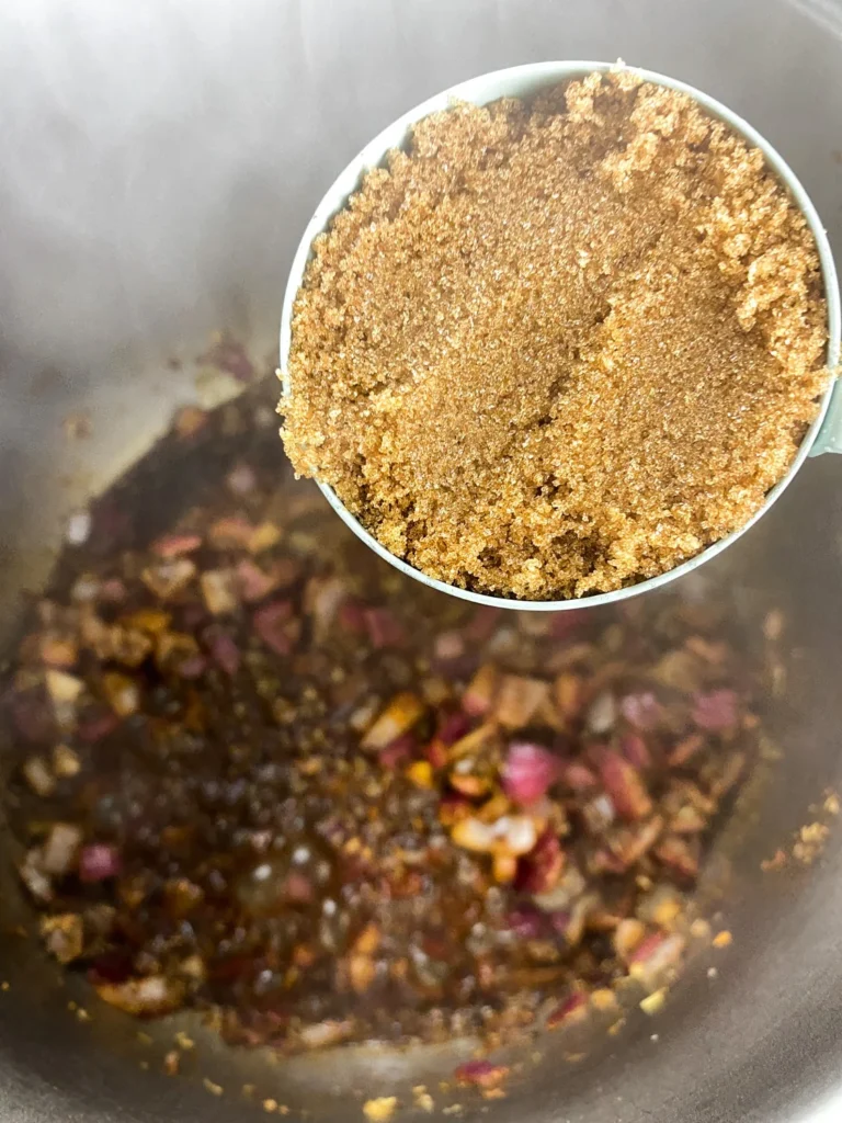 Brown sugar being added to the cherry chutney ingredients in the Instant Pot.