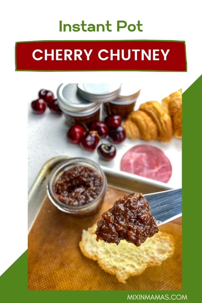 Knife spreading homemade Instant Pot cherry chutney onto toasted bread with croissants and fresh cherries in the background.