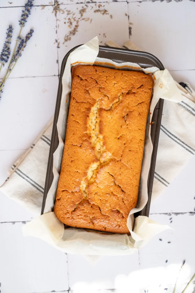 Freshly baked lemon lavender pound cake in a parchment-lined loaf pan.