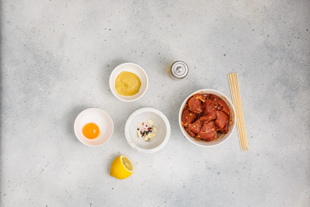 Ingredients for homemade aioli arranged beside the marinated pork.