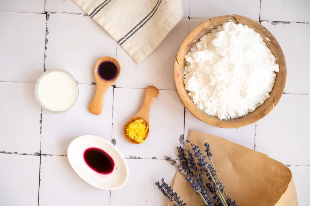 Ingredients for lemon lavender glaze, including powdered sugar, milk, lemon zest, and purple coloring.
