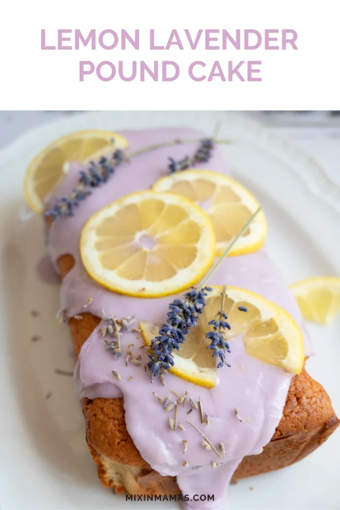 Close-up of lemon lavender pound cake covered in pale lavender glaze and topped with fresh lemon slices and dried lavender.