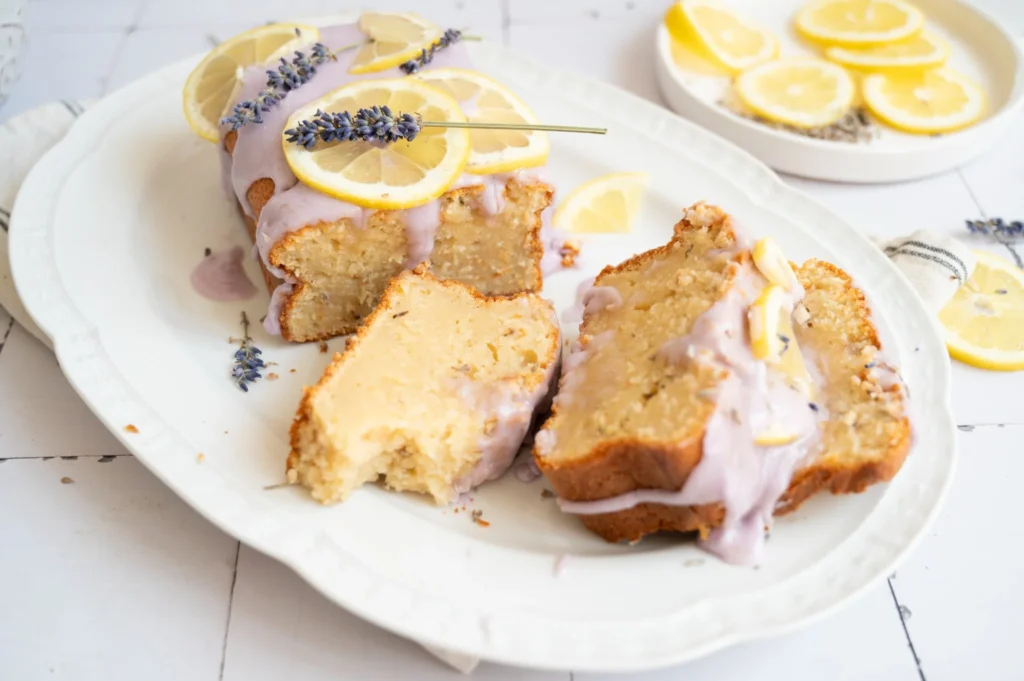Lemon lavender pound cake with several slices showing the moist crumb and pale purple glaze.