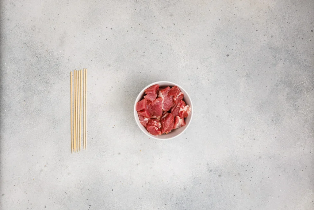Raw pork cut into chunks and ready to marinate for pork skewers.